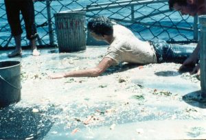 A trusty Shellback scrubs down some lowly pollywogs